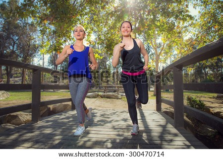 friends train and run jogging together to lose weight cardio training fitness in trees park