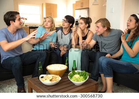 Large group of friends at a party get together house drinking beer chatting storytelling gossiping