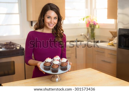 Young beautiful wife woman cook chef baker with fresh batch of cupcakes portrait home sweet homemade