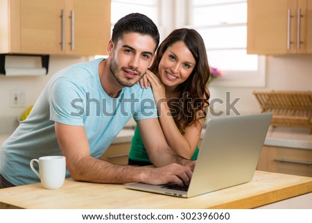 Portrait of model man and woman beautiful handsome home on computer laptop with coffee in the morning day bright home kitchen