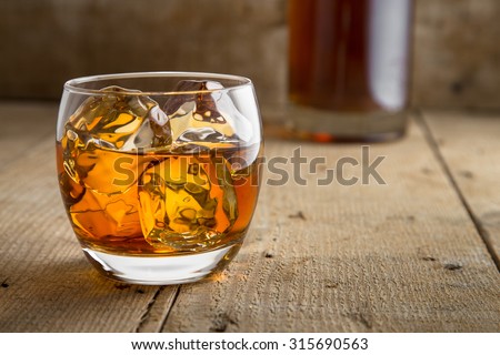 Bourbon brandy and bottle delicious tasty glass on ice classic modern rustic bar table bar saloon barrel