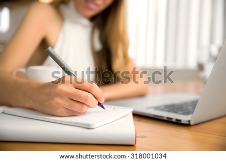 Close up of writer blogger hand laptop computer taking notes studying at home