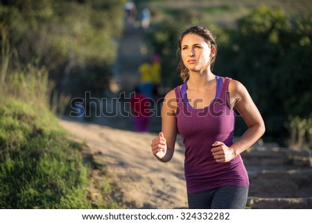 Athlete woman running in nature jogging path determined serious focused mental strength