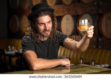 Whisky glass cheers stylish man drinking bourbon at a whiskey distillery restaurant bar