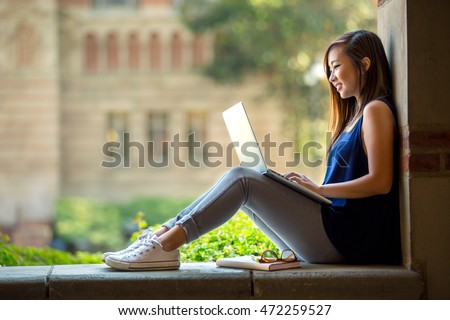 Young asian student on university campus with computer laptop