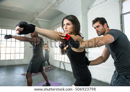 Toned fitness boxing Instructor assists female student punch cardio weight loss gym trainer