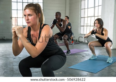 Female instructor leads boot camp class in power yoga pose high intensity cardio unisex coed team