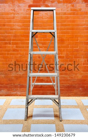 Home improvement concept with ladder and brick wall