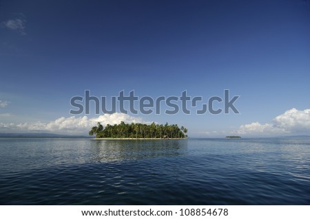 Small island with palm trees forest in middle of blue sea. Kuna Yala, San Blas Archipelago, Panama, Caribbean, Central America.
