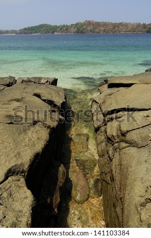 Sea waters entering between rocks in Contadora island shore. Las Perlas archipelago, Panama province, Panama, Central America.