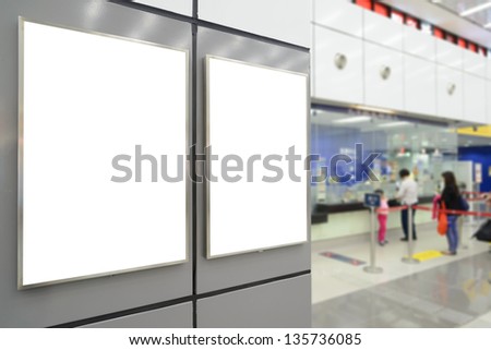 Two big vertical / portrait orientation blank billboard on wall in public open space with passenger background