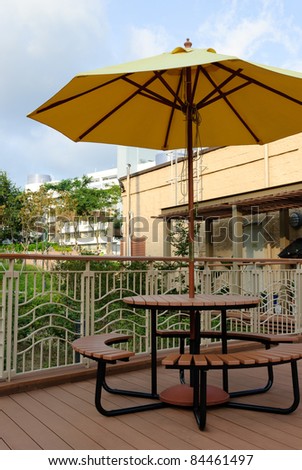 Patio umbrella with blue sky and tree background