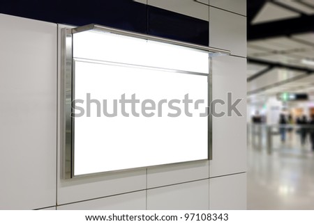 One big horizontal / landscape orientation blank billboard on modern white wall with subway concourse background