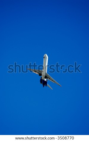 Twin engine jet plane overhead on flight path to land, banked turn, 1