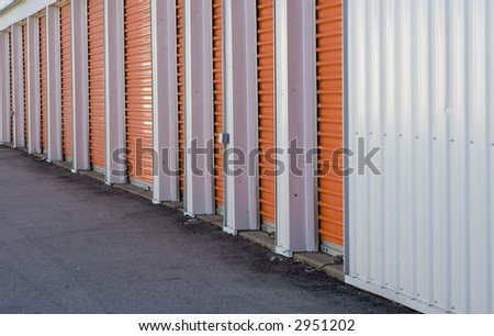 Row of orange door from a storage warehouse alarm system seen at the bottom of each door