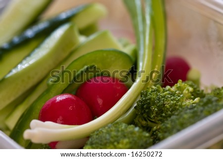 fresh vegetables cut up and in a plastic bowl