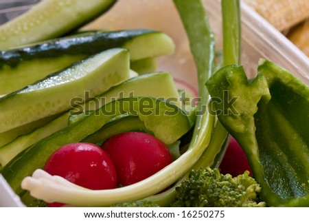 fresh vegetables cut up and in a plastic bowl