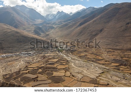 top view of the small Tibetan town. river, houses, fields, mountains merge together