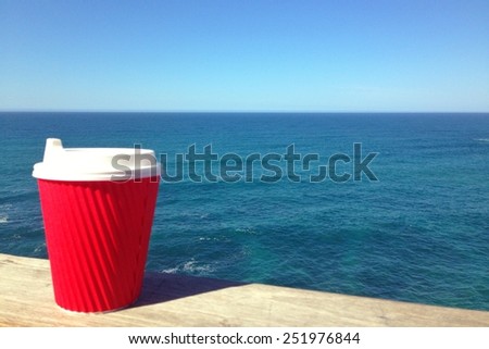 Take away cup of coffee drink by the blue sea sky
