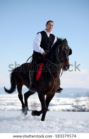 young man riding horse outdoor in winter