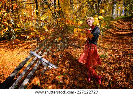 Beautiful elegant blonde woman in autumn forest