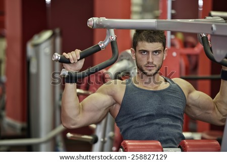 young handsome man exercising in the gym