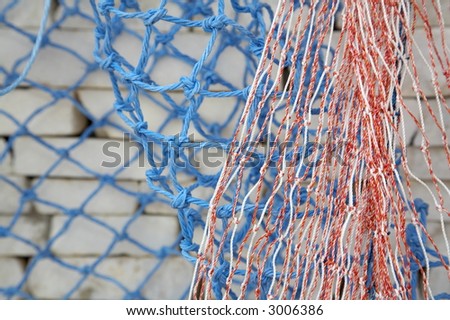 colourfull fishing net and a stone wall in the background