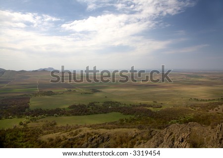 fields and mountains in spring with a blue sky