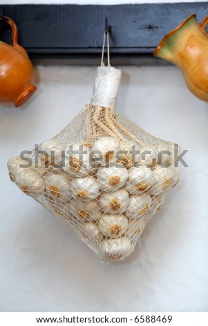 sack of garlic and clay pots hanged up in a rustic restaurant