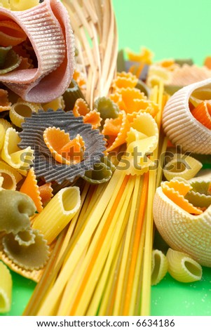 asorted colourful uncooked pasta on green background