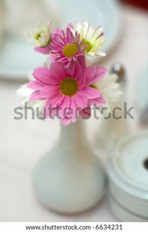 small vase with daisies in a restaurant
