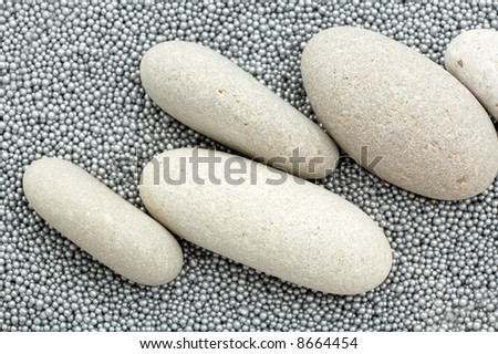 pile of river stones and small metallic balls as background