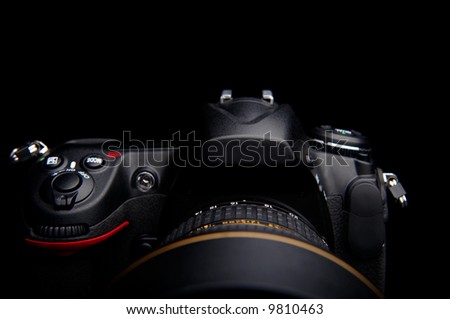 detail of a professional digital photo camera with lens on black background