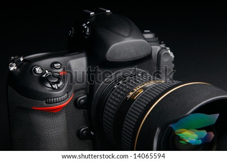 Professional digital photo camera against black background