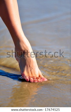 nice woman leg on the wet sand
