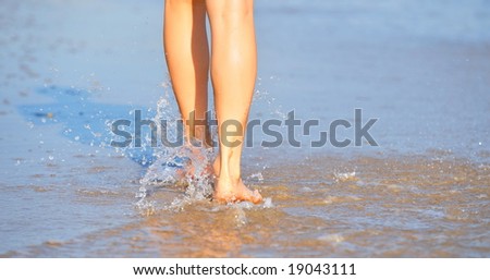 nice woman legs walking on the beach
