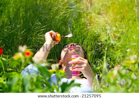young woman outdoor blowing soap balloons