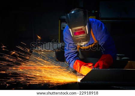 worker welding metal and sparks spreading worker welding metal and sparks spreading