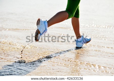 stock photo feet of young woman jogging on the beach at sunrise
