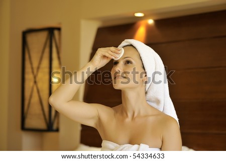 happy young woman cleansing her face