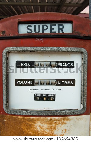 A vintage antique Gasoline fuel pump on red background