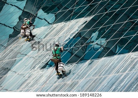 Group of window cleaners cleaning a high rise office building on a sunny day