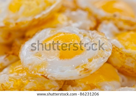 Stack of fried eggs focus on the center egg yolk,can be use for health/Food/breakfast related concept design and background of presentation.