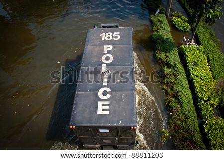 BANGKOK - NOVEMBER 7 : Heavy police truck is driven through water after impact with heaviest flood and rain in 20 years in the capital on November 07, 2011 in Bangkok, Thailand.
