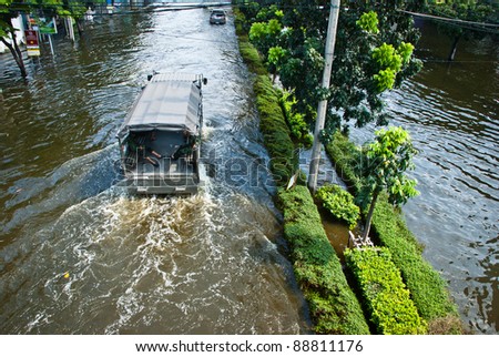 BANGKOK - NOVEMBER 7 : Heavy military truck is driven through water after impact with heaviest flood and rain in 20 years in the capital on November 07, 2011 in Bangkok, Thailand.
