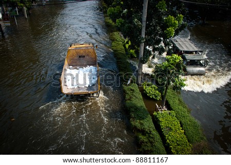 BANGKOK - NOVEMBER 7 : Heavy supplies truck is driven through water after impact with heaviest flood and rain in 20 years in the capital on November 07, 2011 in Bangkok, Thailand.