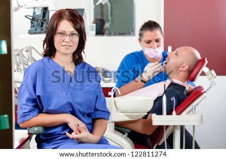 Portrait of a dentist smiling with dentistry work in the background