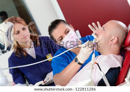 Female dentist doing a medical procedure to her patient