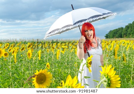 Young girl with an umbrella on a sunflower field