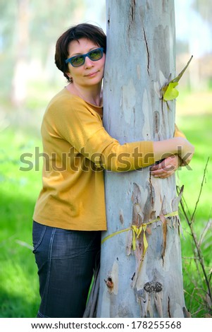 middle aged woman tree hugging